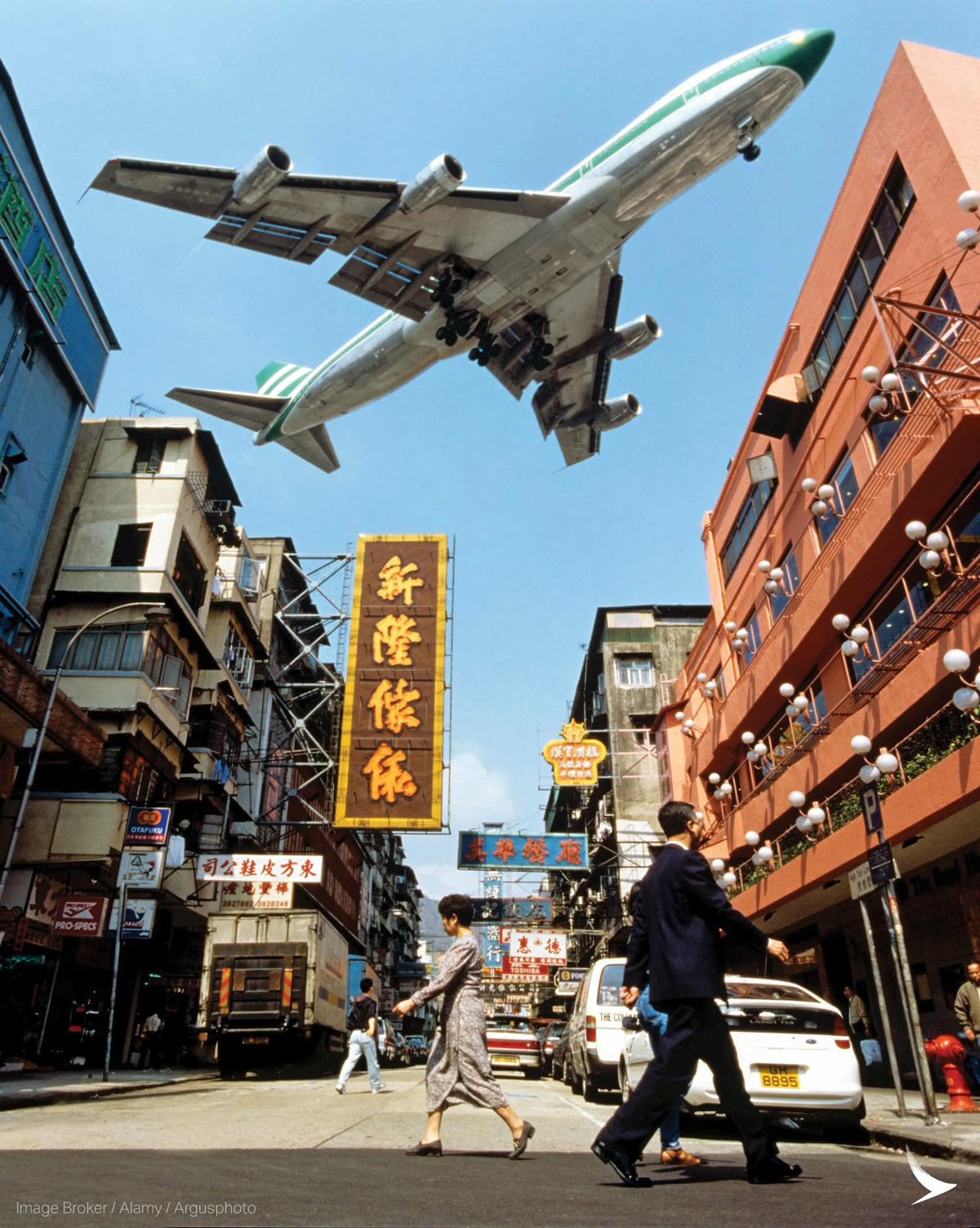 Airplane Hovering Over Urban Street