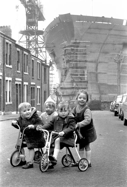 Children on Tricycles Near Shipyard
