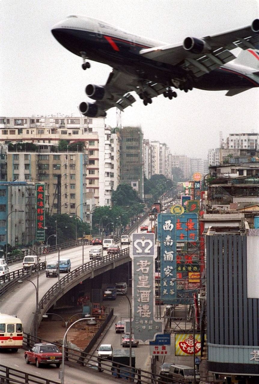 Airplane flying over busy city street