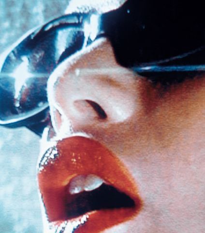 Close-up of glossy lips and sunglasses