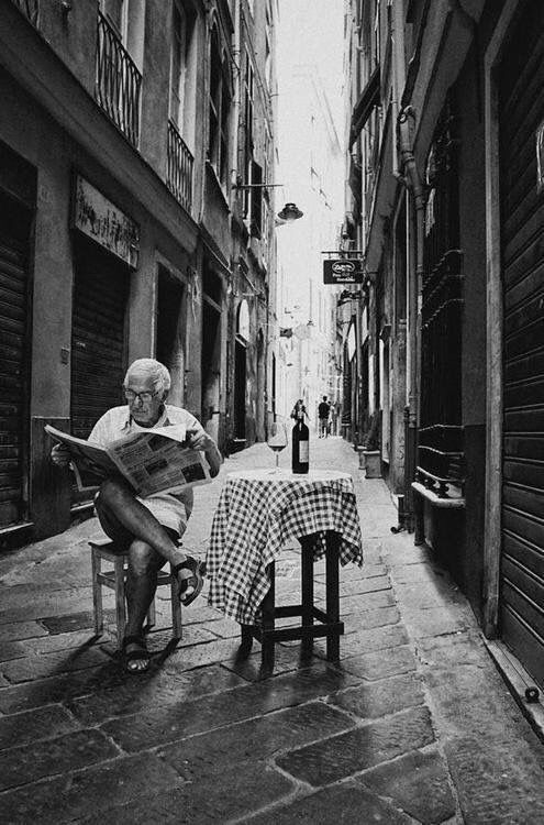 Man Reading Newspaper in Narrow Alley