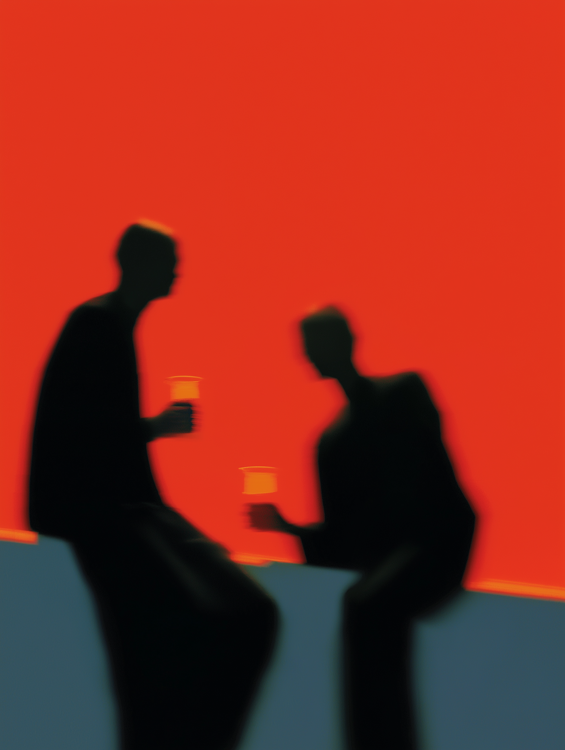 Silhouettes of Two Figures Against Orange Sky
