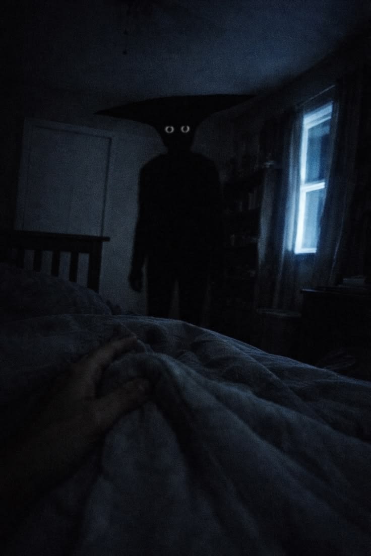Silhouette of a figure in a dimly lit room