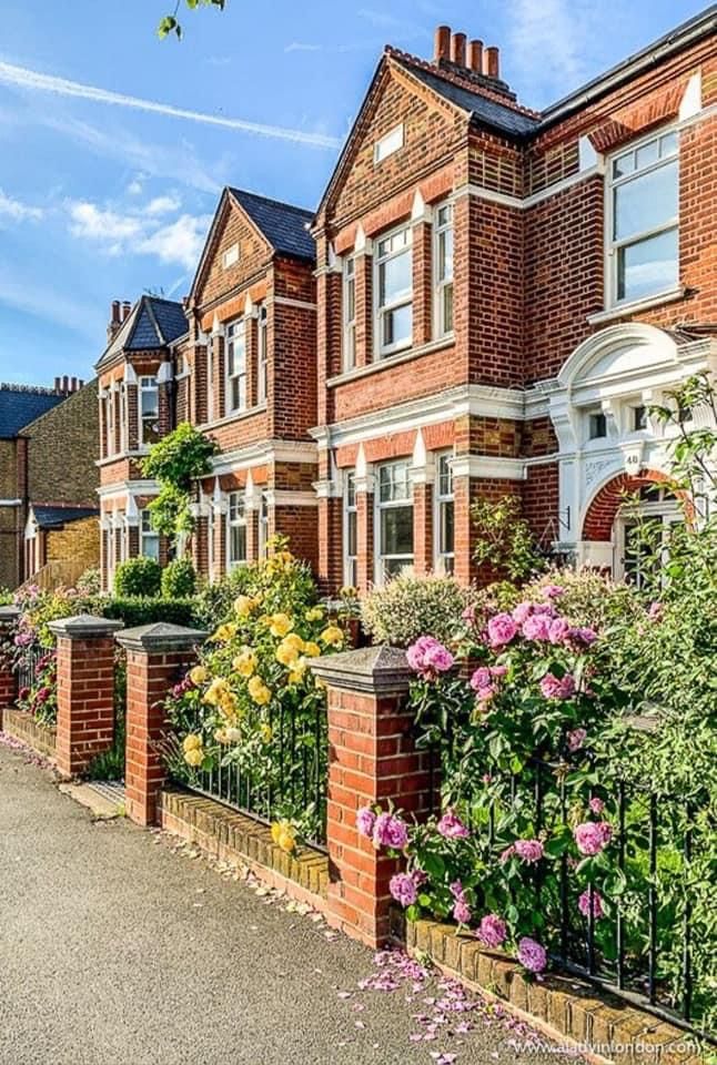 Victorian-style brick houses with vibrant gardens