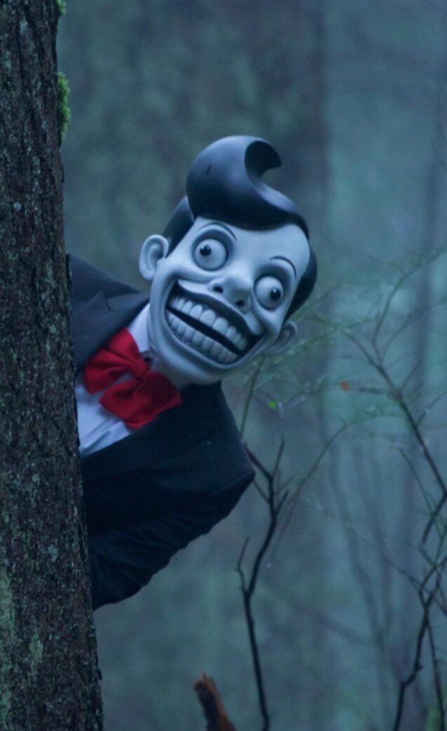 Creepy Puppet Peeking from Tree