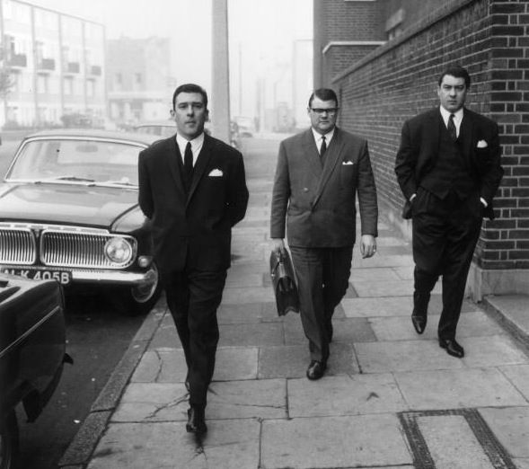 Men in suits walking on a city street