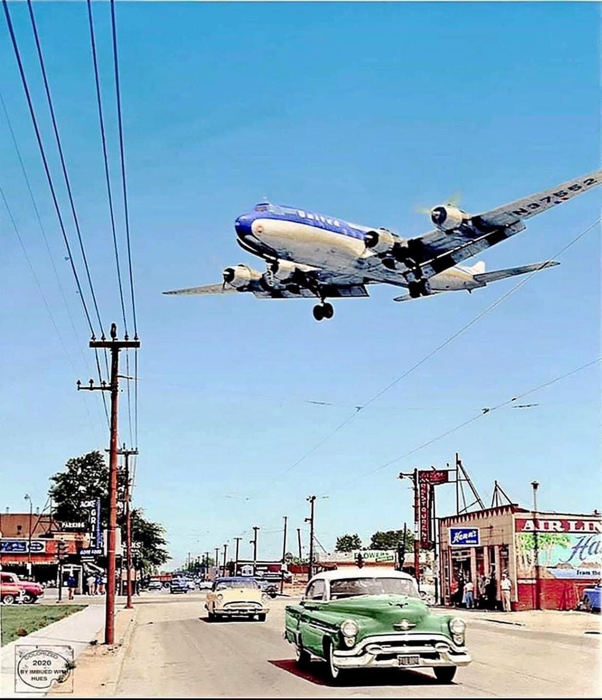 Vintage Airplane Over Urban Street