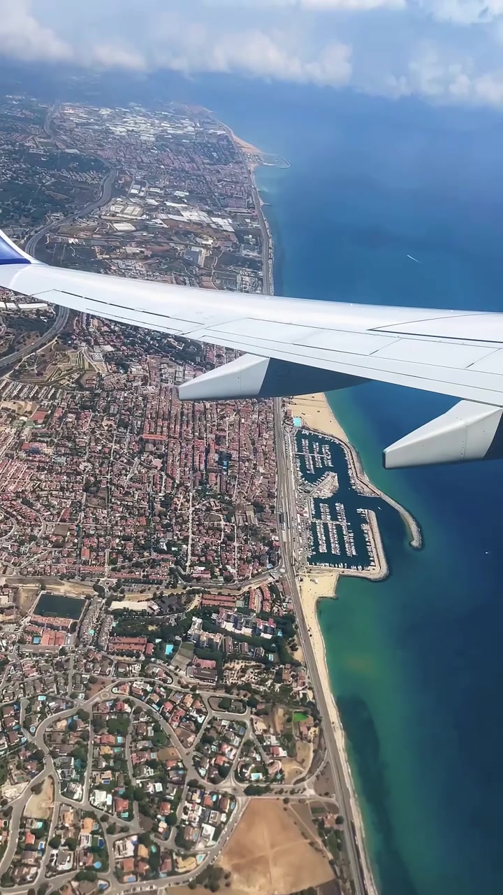 Airplane Wing Over Coastal City