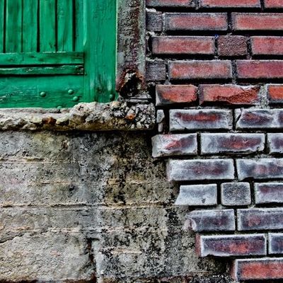 Weathered Brick Wall with Green Shutters