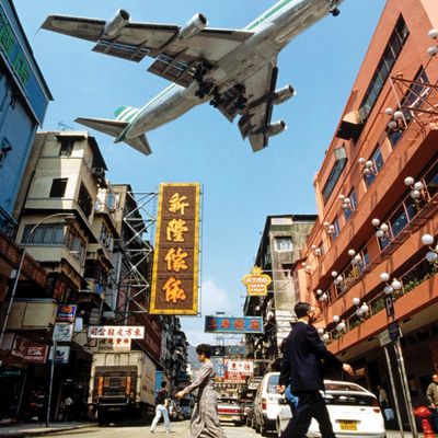 Airplane Hovering Over Urban Street