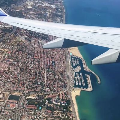 Airplane Wing Over Coastal City