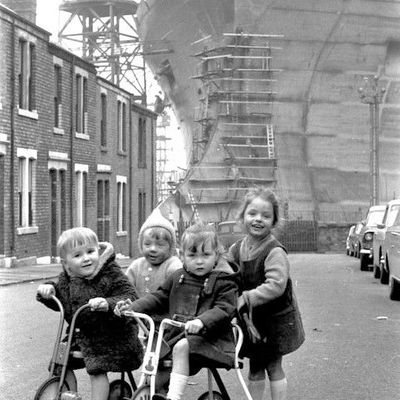 Children on Tricycles Near Shipyard