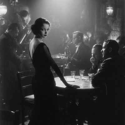 coleshaw 26618 A 1920s speakeasy hostess standing beside a diml 00ddee1e a27f 4fb3 89ff 90f5ee0ae5e9